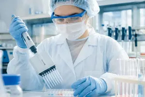 Laborantin arbeitet mit einer Mehrkanalpipette im pharmazeutischen Labor